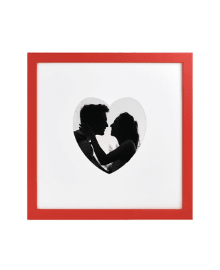 Silhouette of a loving couple inside a heart-shaped cutout within a bright red frame.