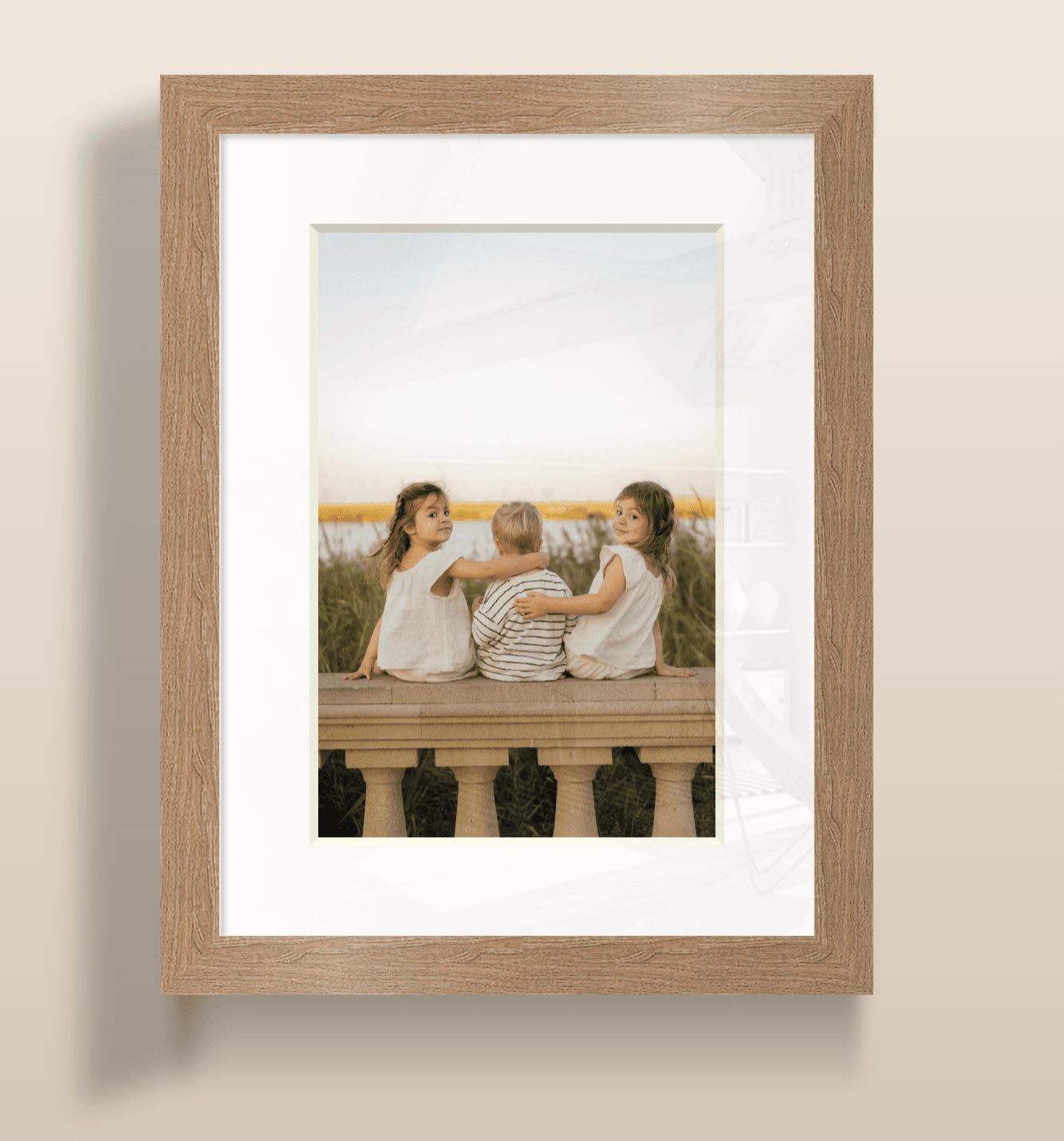 Three children from behind, sitting on a wall, viewing water and tall grasses.