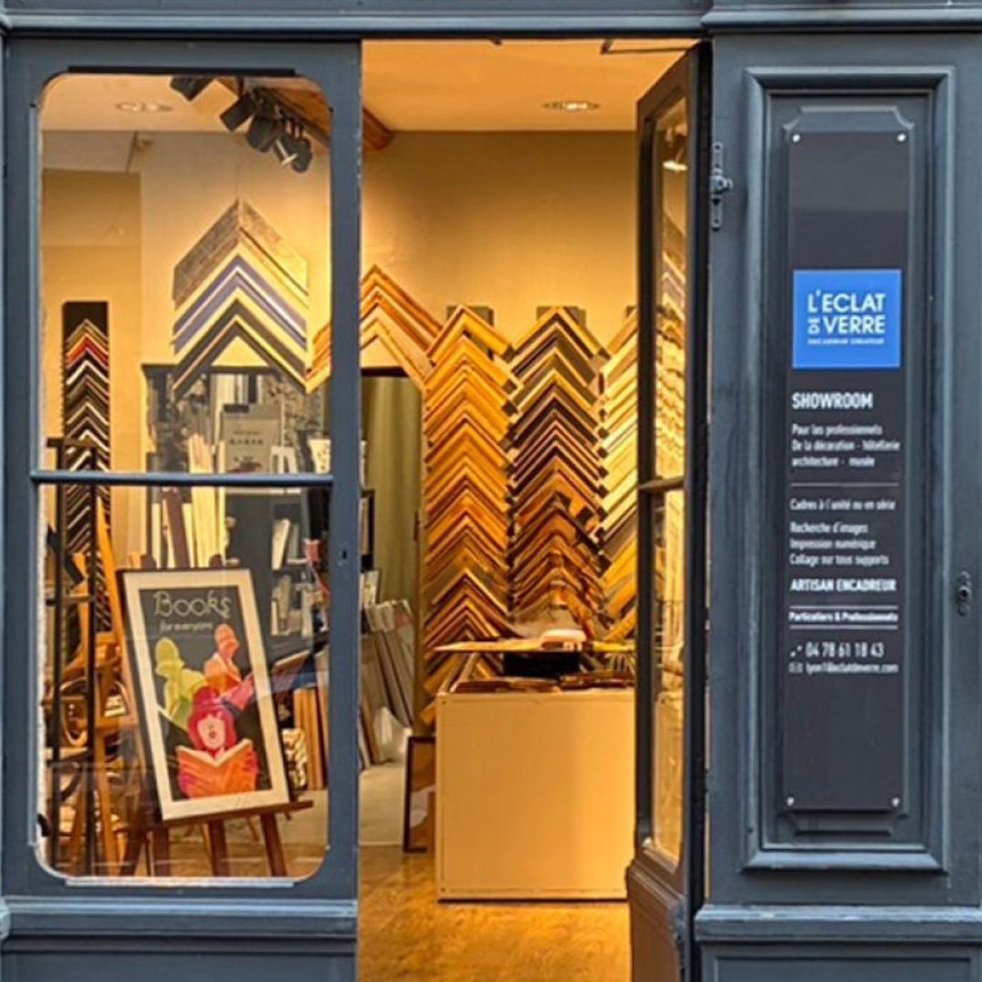 Open doorway of a picture framing shop, displaying various frames and artwork inside.