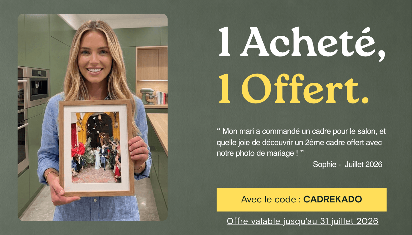 Smiling woman holds framed wedding photo, advertising '1 Acheté, 1 Offert' promotion.
