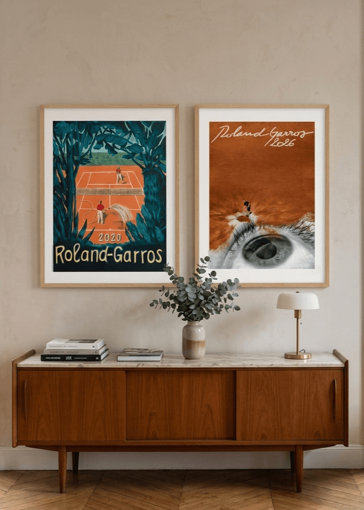 Two framed vintage tennis posters, including Roland Garros, above a mid-century modern credenza.