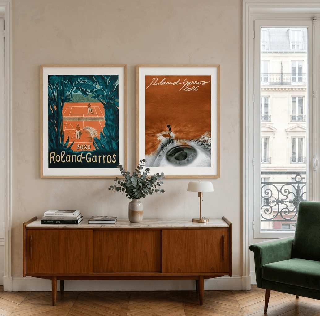 Two framed vintage Roland Garros tennis posters hang above a mid-century modern console table in a stylish room.