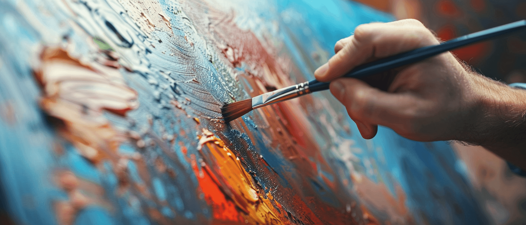 A close-up of a hand holding a paintbrush, applying thick, vibrant paint onto a canvas.