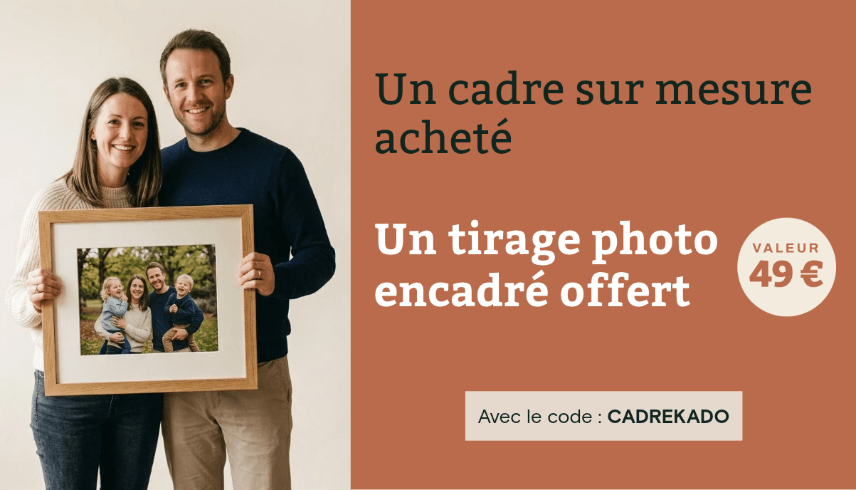 Smiling couple holds framed family photo next to promotion for custom frames.