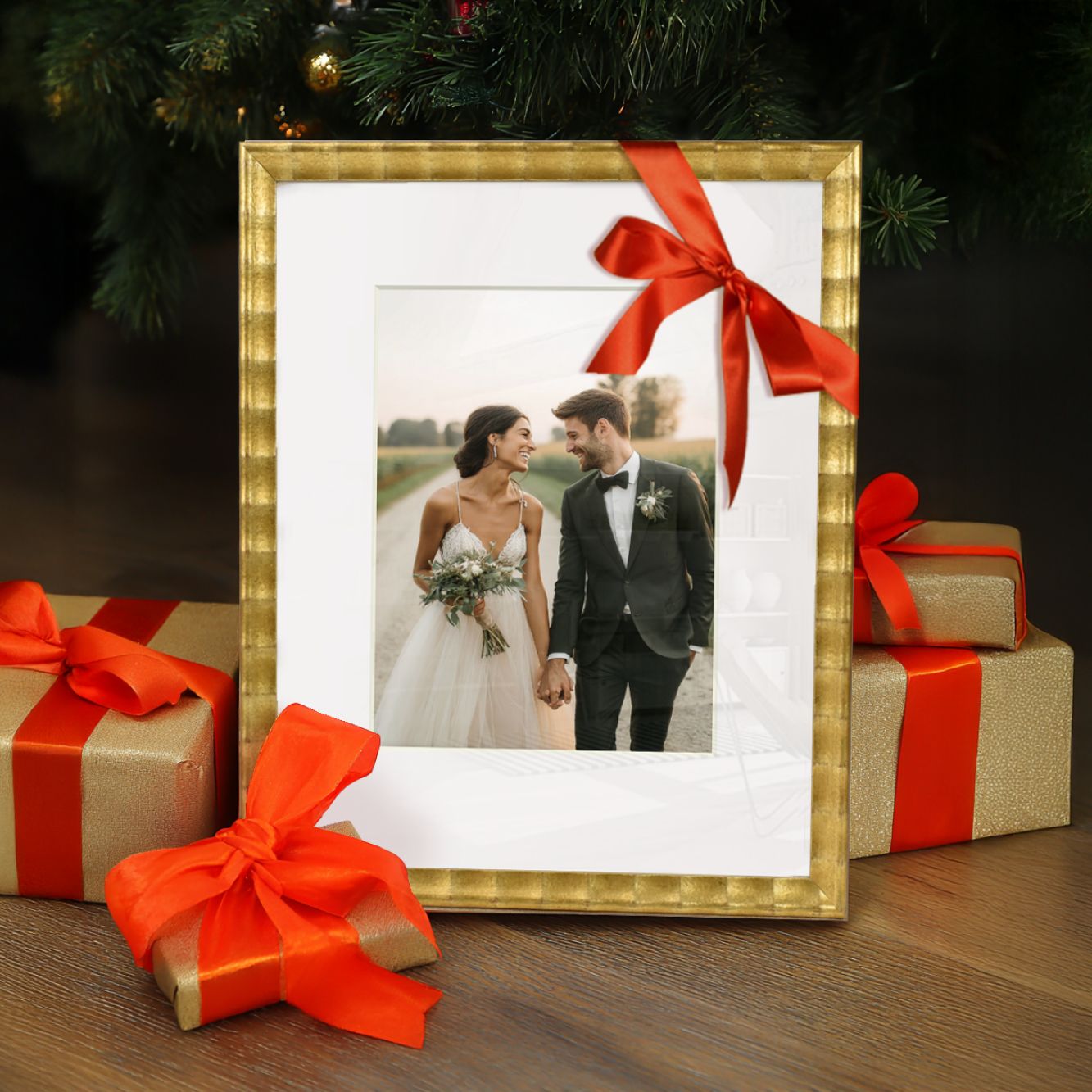 Gold-framed wedding photo of a couple holding hands, festive gifts and a Christmas tree.